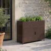 Armoire de jardin 100 cm marron avec jardinière contenant des aromates contre mur en pierres