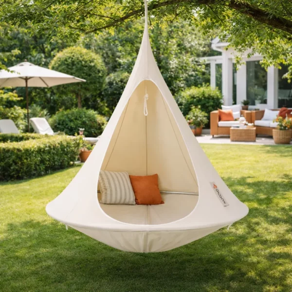 Tente suspendue hamac cocon écru avec coussins installée dans jardin, espace détente extérieur