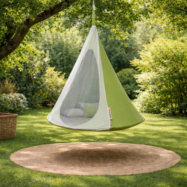 Tente suspendue hamac cocon vert avec moustiquaire installée dans jardin, espace détente extérieur