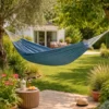 Hamac 1 place en coton bleu suspendu entre arbres dans jardin, toile hamac extérieur détente